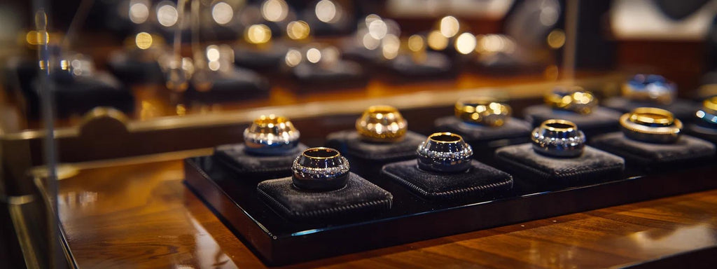 a polished display of exquisite luxury rings for men, elegantly arranged on a sleek black velvet tray, set against a soft, ambient-lit upscale jewelry store interior, capturing the essence of the perfect holiday gift